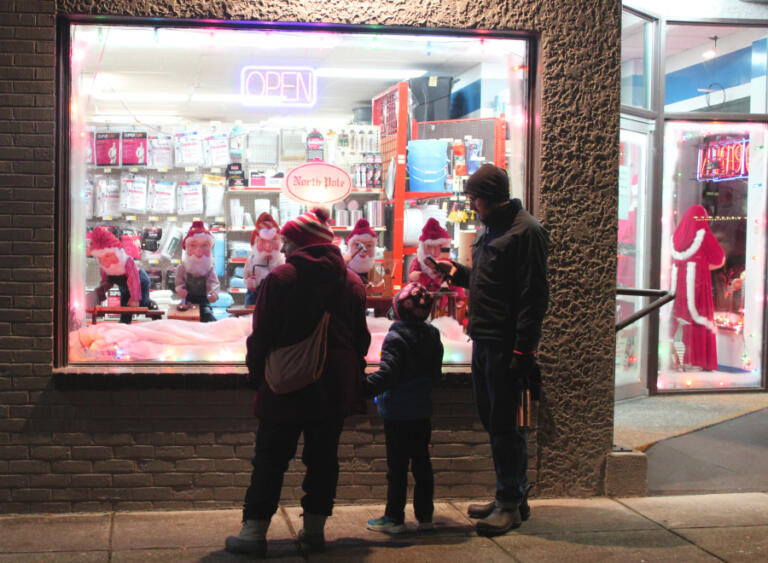 2024 Hometown Holidays visitors admire a holiday window display at Lutz Hardware in downtown Camas, Friday, Dec.