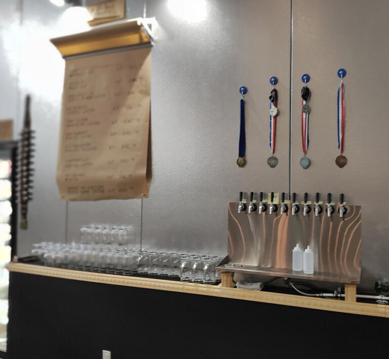Doug Flanagan/Post-Record 
 Medals hang above the beer taps behind the bar at the Recluse Brew Works taproom on Jan. 11, 2025. Recluse beers earned the medals at three beer competitions in 2024.