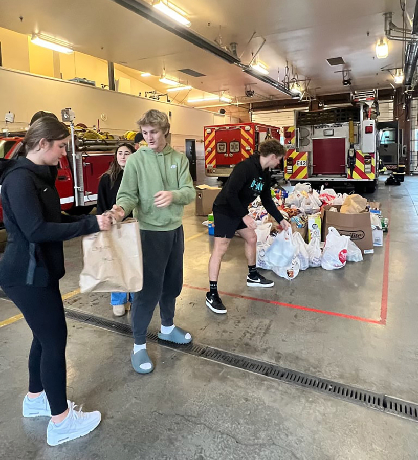 Washougal High School senior Riley Vaughan (far left) organizes food for the 2024 Stuff the Bus campaign in December 2024.