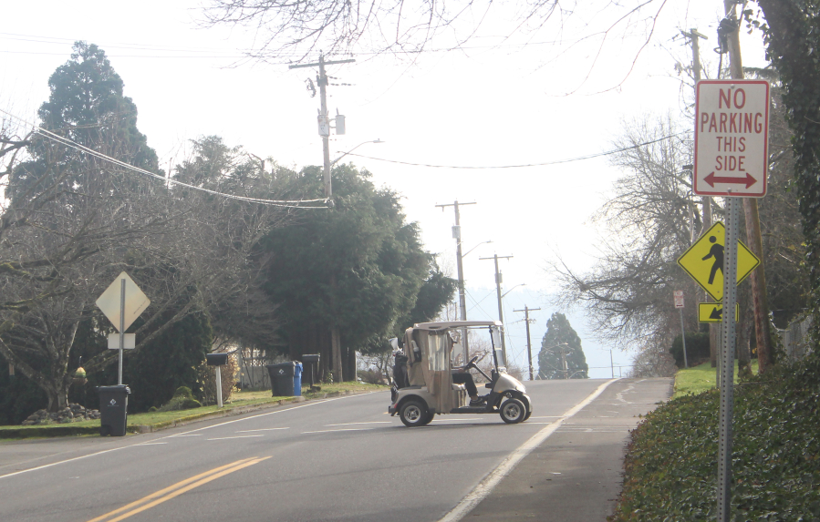 A golfer drives a cart across 39th Street to Orchard Hills Golf Course in Washougal on Jan. 17, 2025.