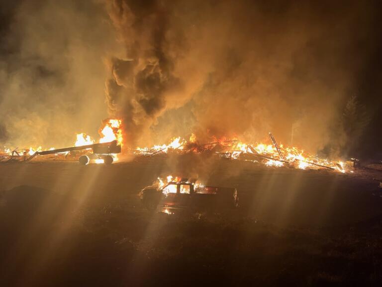 A two-story home under construction on Northeast Livingston Mountain Circle in Camas and nearby vehicles are engulfed in flames early Sunday morning, Jan. 26, 2025.