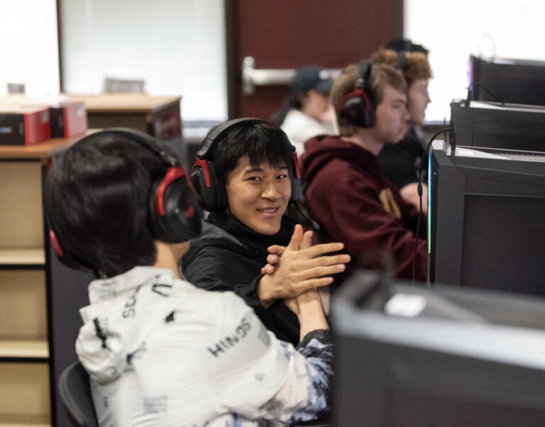 Esports team members Dillon Thai, center, and Eason Ni, left, both sophomores, celebrate after a win on March 19 at Prairie High School.
