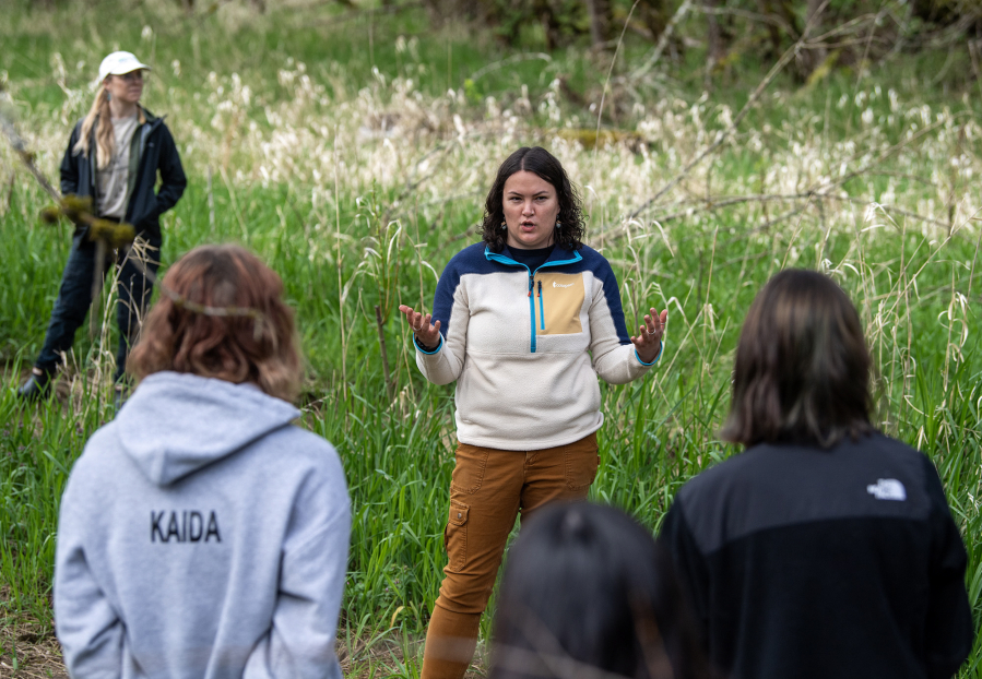Portland State University Indigenous Traditional Ecological and Cultural Knowledge Coordinator Emma Johnson talks to Hudson’s Bay High School students about the importance of the flora they are about to plant Wednesday, April 9, 2025, at Baz River Front Park in Camas.