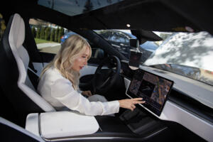 Driver Natalya McAleer looks over the inside of a Tesla Plaid, which is an electric vehicle, in Vancouver on Tuesday, April 15, 2025. McAleer is part of the roughly 20 percent of new car buyers switching to electric or plug-in hybrid electric cars. (Amanda Cowan/The Columbian)