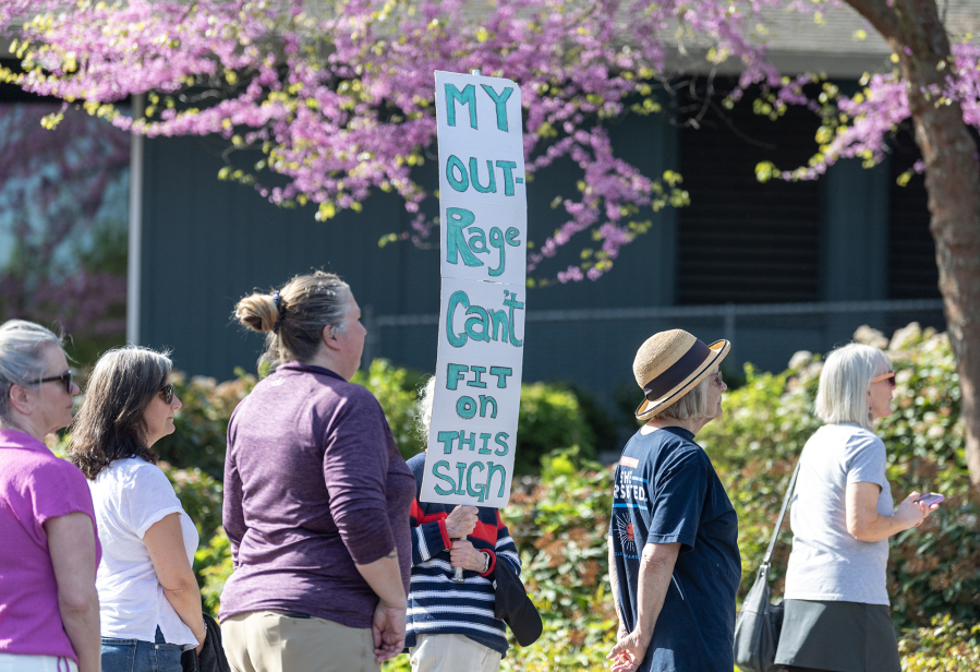 A person holds up a sign while waiting in line for a town hall with Rep. Marie Gluesenkamp Perez on Thursday in Vancouver.