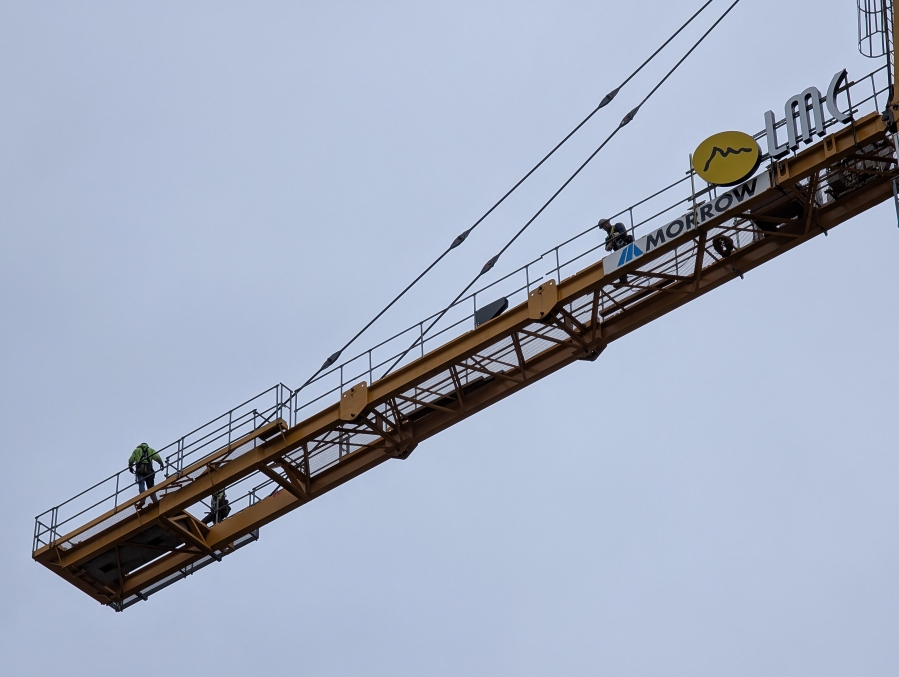 Construction crew members walk along a portion of the newly installed tower crane at the Hyas Point construction site May 13. (Contributed by Central Bethany Construction)