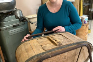 Two Rivers Heritage Museum Director Julianne Lawrence shows visitors an Oregon Trail butter churn included in the Washougal museum’s collection of historical artifacts. (Contributed by Two Rivers Heritage Museum)