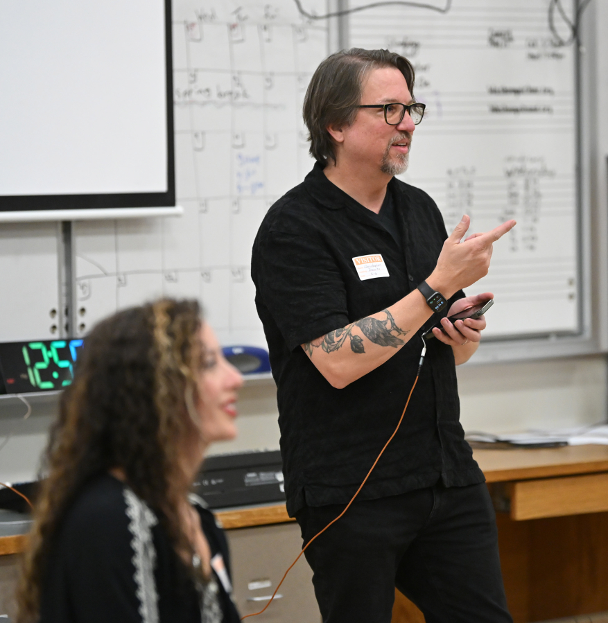 Christopher Corbell, right, plays a song for students May 6 at Washougal High School. The Corbells run the Washougal Songcraft Festival. (Taylor Balkom/The Columbian)
