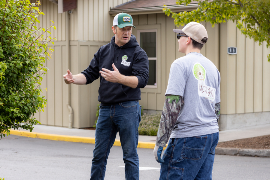 Matt Overton teaches Tyler Stimmel, 16, how best to care for a plant. (Tommy Rhodes for The Columbian)