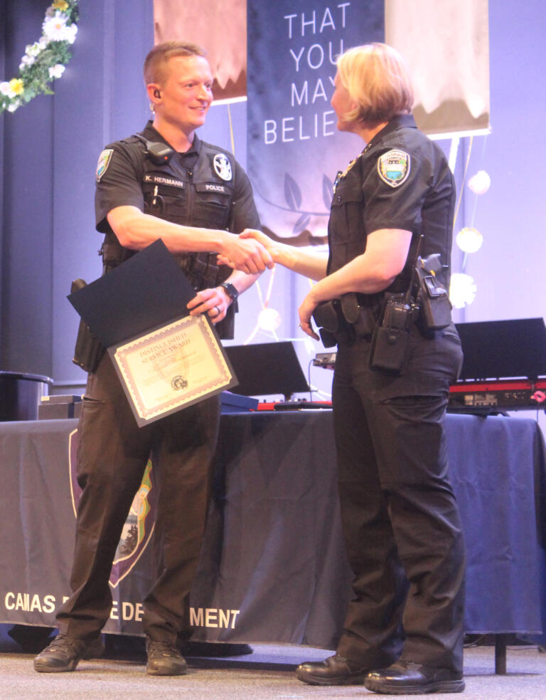 Camas Police Department officer Kevin Hermann (left) receives a Distinguished Service Award from chief Tina Jones during the department's awards ceremony on May 30 in Camas.