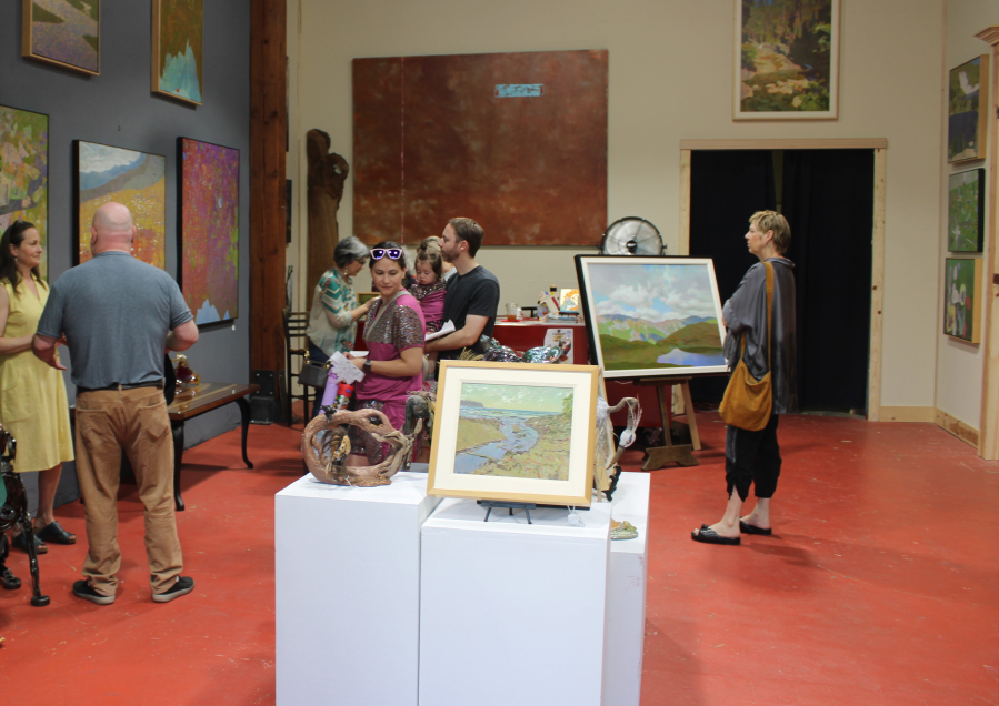 Camas First Friday visitors admire the artwork of Washington artist Michael Ferguson inside the newly reopened Attic Gallery in downtown Camas on Friday. (Kelly Moyer/Post-Record)