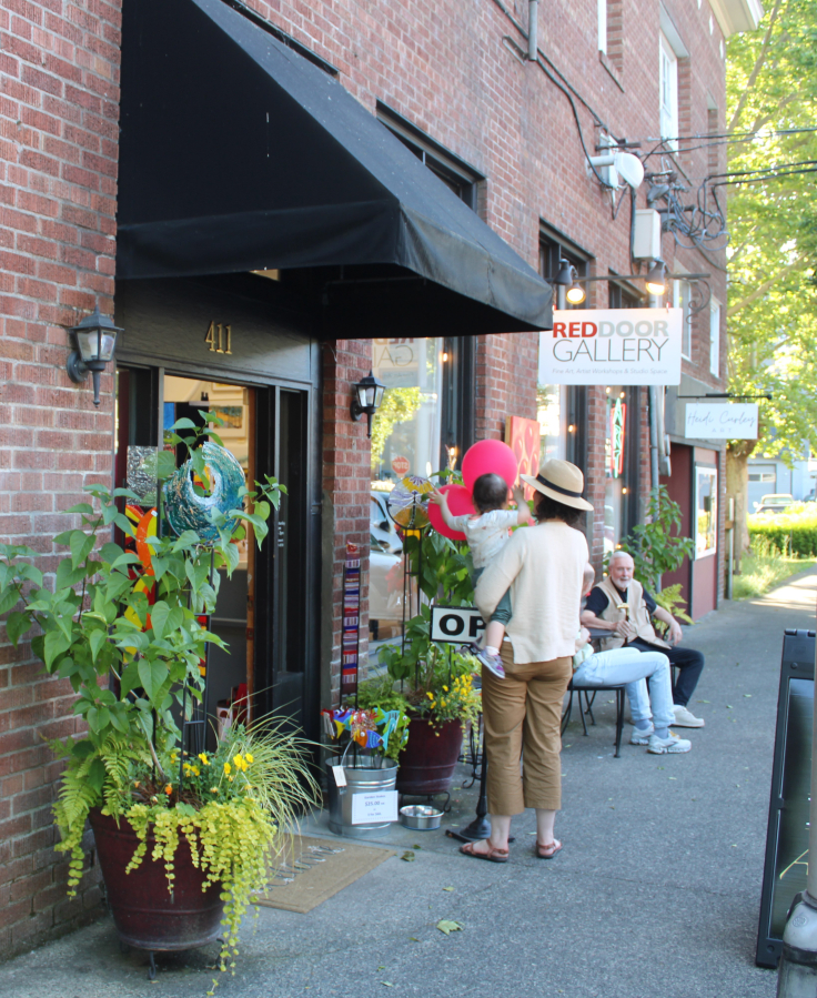 A family passes by the RedDoor Gallery in downtown Camas during the Downtown Camas Association’s First Friday celebration on Friday. (Kelly Moyer/Post-Record)