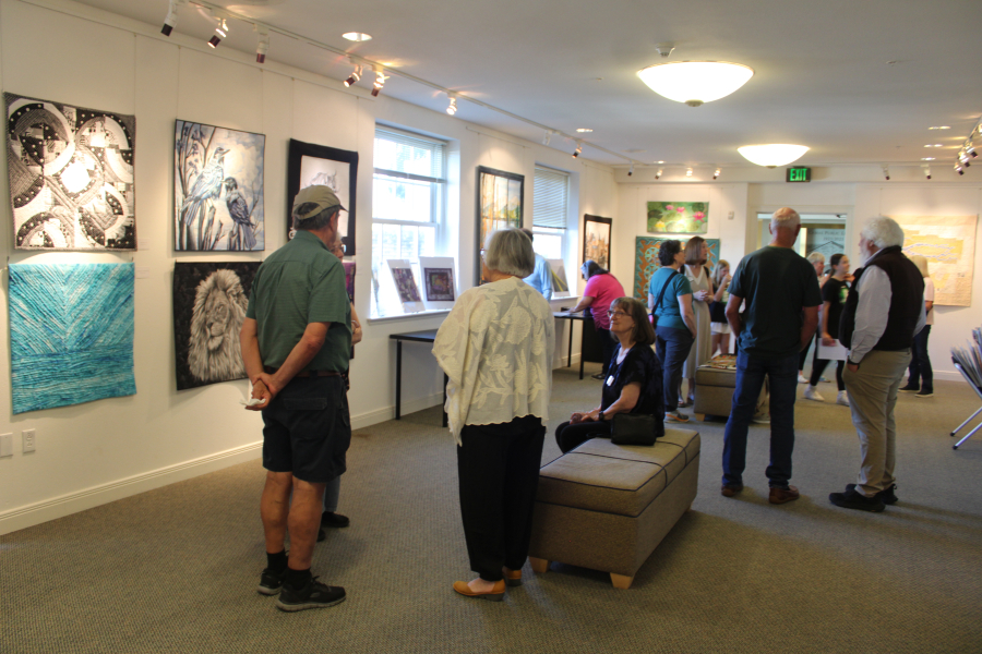 A crowd gathers inside the Second Story Gallery, located on the second floor of the Camas Public Library in downtown Camas for the gallery’s Storyteller Quilters’ art show opening on Friday. (Kelly Moyer/Post-Record)
