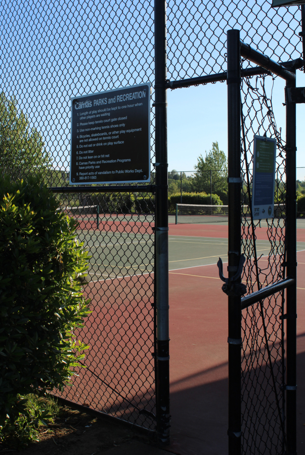 A city of Camas sign is posted next to an open door outside the city’s shared-use pickleball-tennis court at Grass Valley Park on June 6. (Kelly Moyer/Post-Record)
