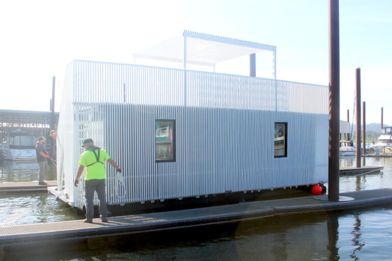 Port of Camas-Washougal employees place a boathouse into the Columbia River at Parker&rsquo;s Landing Marina on June 6.