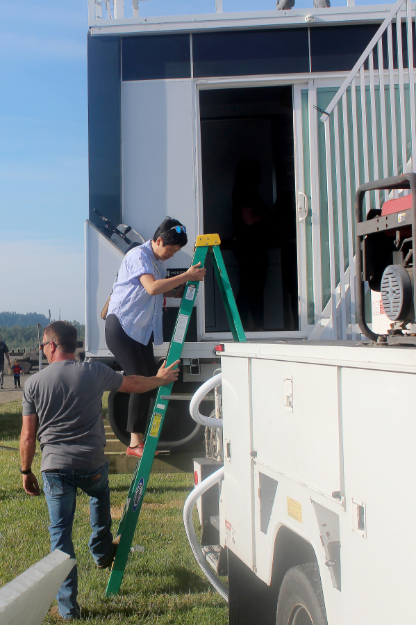 Port of Camas-Washougal CEO Trang Lam steps down from the port&rsquo;s new boathouse as Facilities Director Eric Plantenberg holds a ladder at Parker&rsquo;s Landing Marina on June 6.