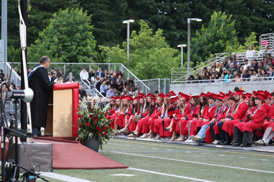 Camas High School teacher Mark Tomasetti, left, delivers a commencement address to the class of 2025 at Doc Harris Stadium in Camas on Friday. (Courtesy of Doreen McKercher, Camas School District)