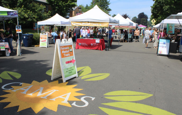 A sign pointing toward a booth offering farmers market tours greets visitors at the 18th annual Camas Farmer's Market on Wednesday afternoon, June 11, 2025.