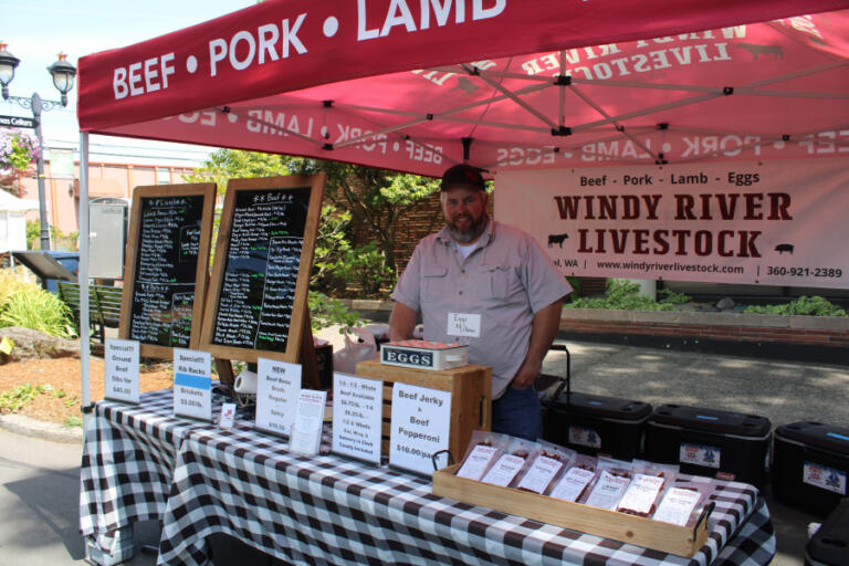 Washougal farmer Will Stauffer, a Camas native, stands inside his Windy River Livestock vendor booth near the corner of Northeast Fourth Avenue and Northeast Everett Street in downtown Camas at the Camas Farmer's Market on Wednesday afternoon, June 11, 2025.