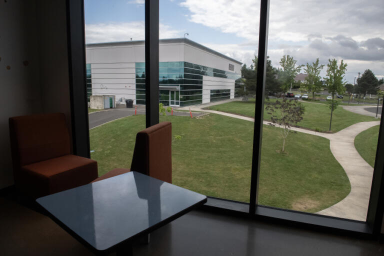 Chairs and a table are seen inside Discovery High School, left, as Odyssey Middle School is visible from the second floor window in Camas on Thursday afternoon, May 22, 2025. The Camas School District purchased the Odyssey building and 31 acres of land from Sharp Laboratories of America for $12.5 million in 2016, and used proceeds from a $120 milion voter-approved facilities bond to construct the $45 million Discovery High School in 2018.