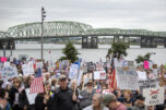 The Interstate 5 Bridge crosses the Columbia River behind a large crowd of protesters participating in the nationwide &ldquo;No Kings&rdquo; rally on Saturday on Waterfront Way at the Vancouver waterfront. (Photos by Taylor Balkom/The Columbian)