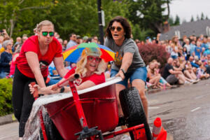 The Helen Baller Elementary team with Caitlan Wagner, from left, Anitra Quist and pilot Melissa Butler were knocked out of the competition in early rounds of the Camas Days bathtub races July 24, 2022, in downtown Camas. (The Columbian files)