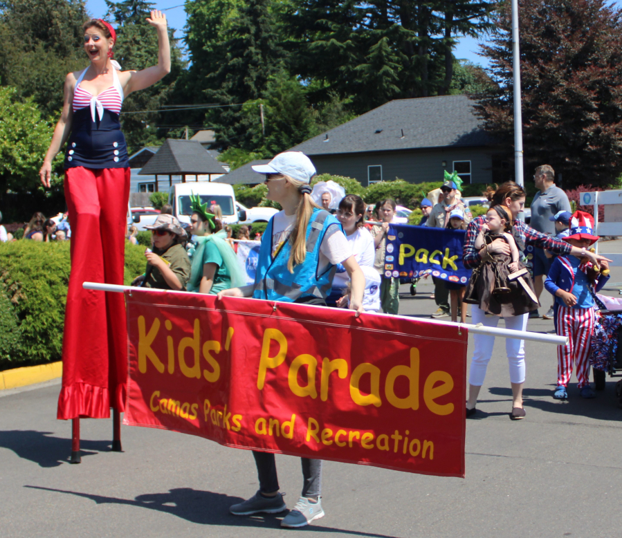 A stiltwalker and Camas Parks and Recreation staff lead the 2024 Camas Days Kids Parade through downtown Camas on July 26, 2024. (Kelly Moyer/Post-Record files)