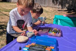 Children paint rocks during the city of Washougal’s first Parks Passport event at the Washougal Community Garden on July 12.