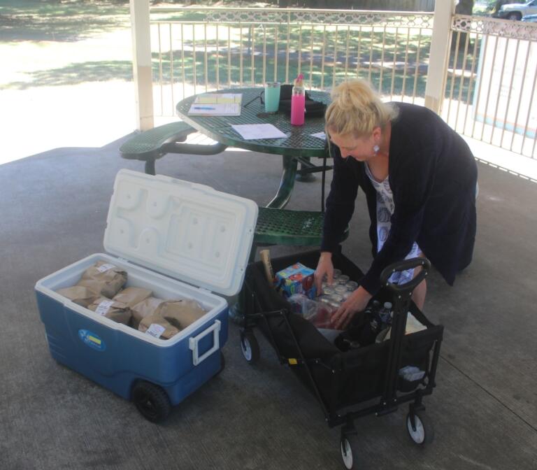 Refuel Washougal volunteer Kerry O&rsquo;Connor packs meals into a storage cart at Hathaway Park on July 25.