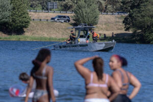 Officials respond to a report of a drowning swimmer at Horseshoe Lake Park as swimmers look on in Cowlitz County on Monday afternoon. (Amanda Cowan/The Columbian)