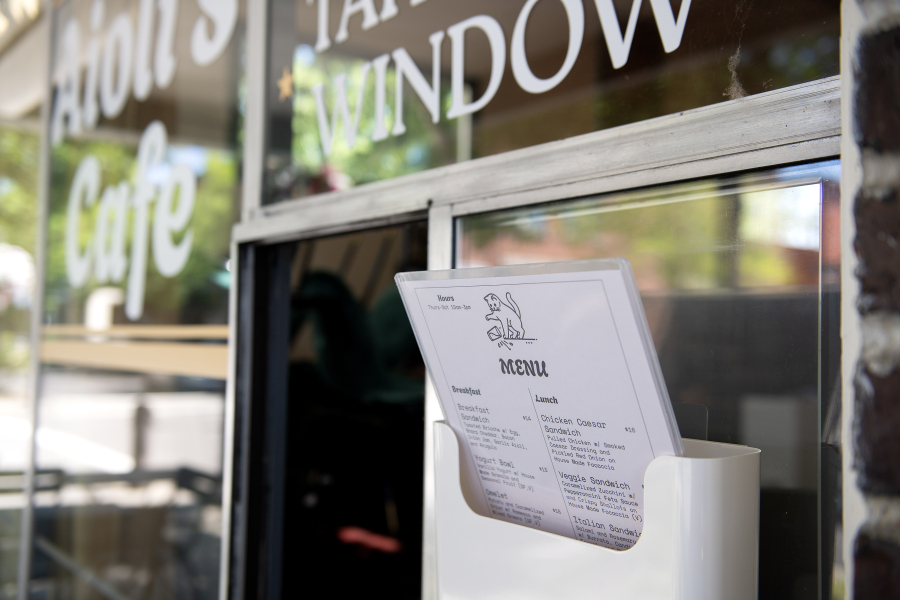 Menus at the takeout window of Aioli’s Cafe in downtown Washougal list breakfast bowls and sandwiches. (Amanda Cowan/The Columbian)