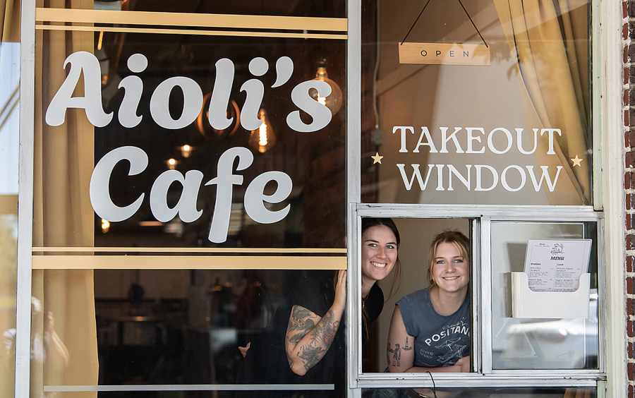 Kara Hendrie, left, and Emma Albertini take a break at Aioli&rsquo;s Cafe in downtown Washougal on July 3. The cafe, operated through a takeout window on the south side of Miere Catering at 1801 Main St., offers breakfast bowls, sandwiches and more. (Photos by Amanda Cowan/The Columbian)