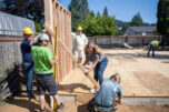 Evergreen Habitat for Humanity&rsquo;s major gift and procurement manager, Kelsey Castrey, center, holds a brace while Ashley Matsen screws it in place Friday, July 11, in Washougal. The single-family, four-bedroom house is the first built in Washougal by Evergreen Habitat For Humanity. (Taylor Balkom/The Columbian)