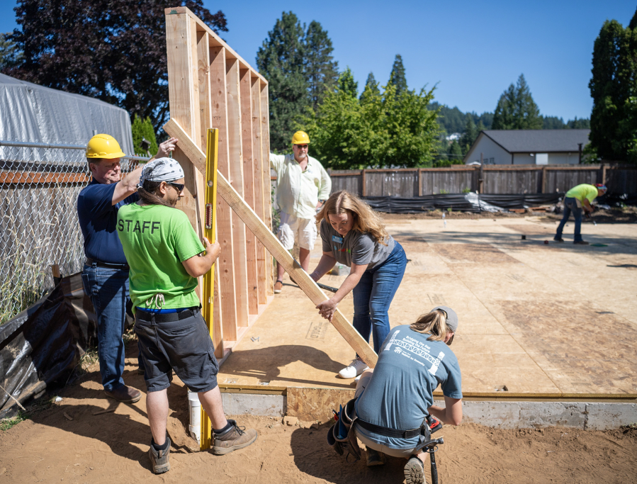Evergreen Habitat for Humanity&rsquo;s major gift and procurement manager, Kelsey Castrey, center, holds a brace while Ashley Matsen screws it in place Friday, July 11, in Washougal. The single-family, four-bedroom house is the first built in Washougal by Evergreen Habitat For Humanity. (Taylor Balkom/The Columbian)