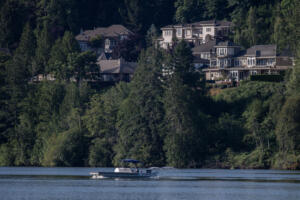 City of Camas crews travel along Lacamas Lake while spraying aluminum sulfate to the water on Tuesday morning in hopes of eliminating harmful algae blooms. (Amanda Cowan/The Columbian)