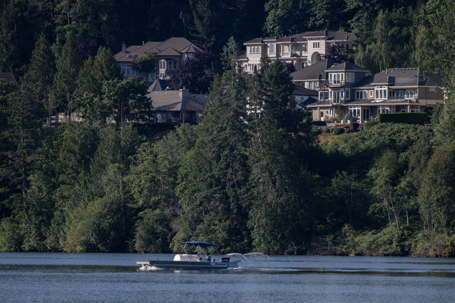 City of Camas crews travel along Lacamas Lake while spraying aluminum sulfate to the water on Tuesday morning in hopes of eliminating harmful algae blooms. (Amanda Cowan/The Columbian)
