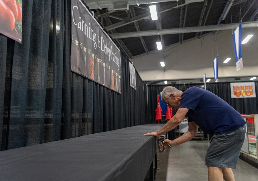 Cal Crawford uses a staple gun to prepare a table at the Canning and Dehydrating department of the Clark County Fair on Tuesday during setup for the fair at the Clark County Event Center at the Fairgrounds.