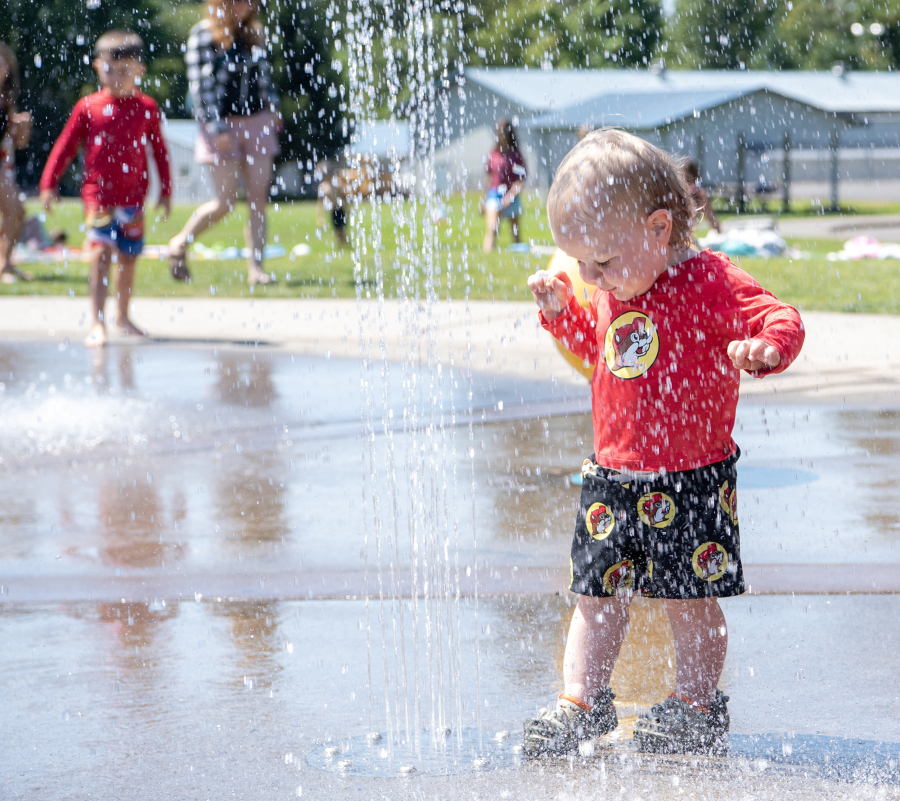 Bradley Englund, 1, cautiously steps on a sprinkler Tuesday at the Holley Park splash pad in La Center. “It is busy all the time from the day it opens to the day we close,” La Center Public Works and Community Development Director Tracy Coleman said. (Taylor Balkom/The Columbian)