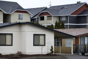 One-story homes at Meadow Verde Mobile Home Park, foreground, are seen in the shadow of apartments in Hazel Dell. A Clark County renter would need to earn more than $33 an hour or work 83 hours at minimum wage to afford a one-bedroom apartment at the fair market rate of $1,750 a month, according to the National Low Income Housing Coalition’s Out of Reach report. (Amanda Cowan/The Columbian files)