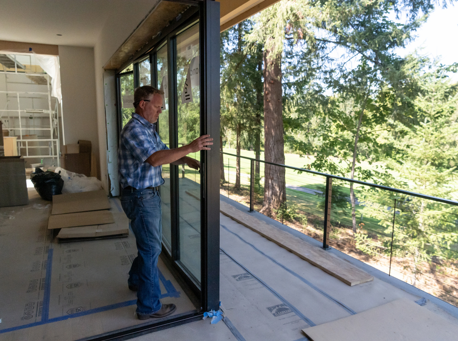 Urban NW Homes owner Jerud Martin opens a NanaWall sliding glass corner in a home to be featured in September&rsquo;s Parade of Homes in Camas. (Photos by Taylor Balkom/The Columbian)