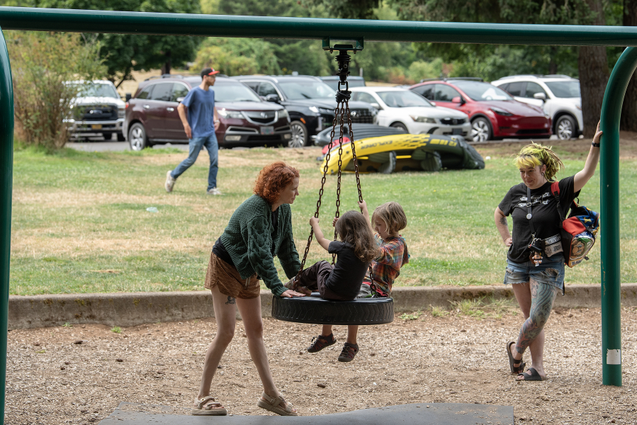 Meghan Sciascia of Vancouver, from left in green, enjoys playtime at Heritage Park with her daughter, Paloma, 4, as well as Ricky Thayer-Daughtery, 5, of Camas and his mom, Faith, on July 31. The city of Camas is partnering with a crowd-tracking company to get an accurate count of parks visitors. (Photos by Amanda Cowan/The Columbian)