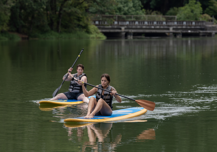 Jaclyn Kopalek, left, and Blair Harvey, both of Portland, cruise the waters of Lacamas Lake as they paddle toward Heritage Park on July 31. The city of Camas is working with Placer.ai to track how many of the visits to Camas parks are coming from outside the city or the state.
