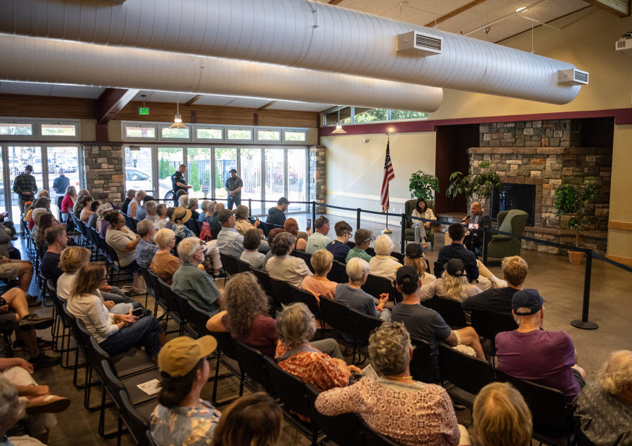 At left, the audience listens to Rep. Marie Gluesenkamp Perez answer a question during Wednesday&rsquo;s town hall. Compared with other recent town halls for Perez, the Battle Ground event was more subdued with just a few outbursts from protesters in the crowd. (Photos by Taylor Balkom/The Columbian)
