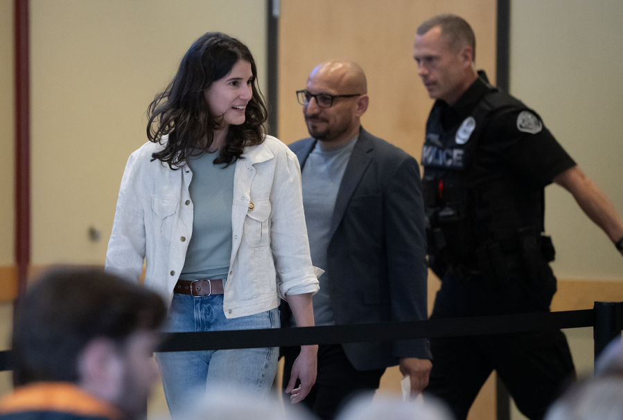 U.S. Rep. Marie Gluesenkamp Perez, D-Skamania, left, walks into the Battle Ground Event Center on Wednesday, accompanied by Clark County Councilor Wil Fuentes, center, and a security officer, ahead of a town hall. (Taylor Balkom/The Columbian)