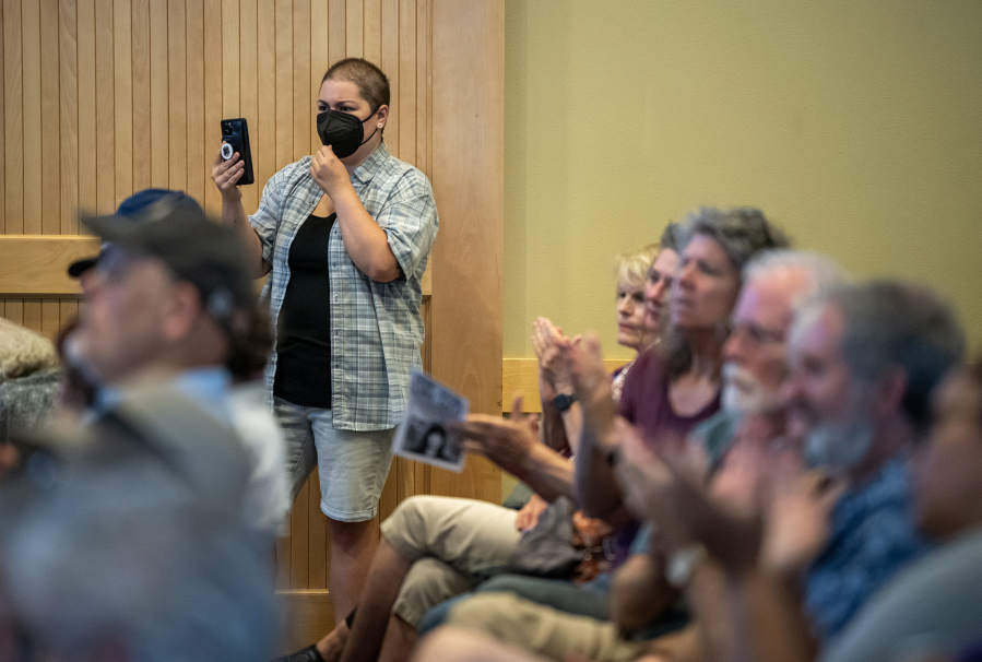 An audience member films while others applaud during a town hall with U.S. Rep. Marie Gluesenkamp Perez, D-Skamania, Wednesday at the Battle Ground Event Center. (Taylor Balkom/The Columbian)