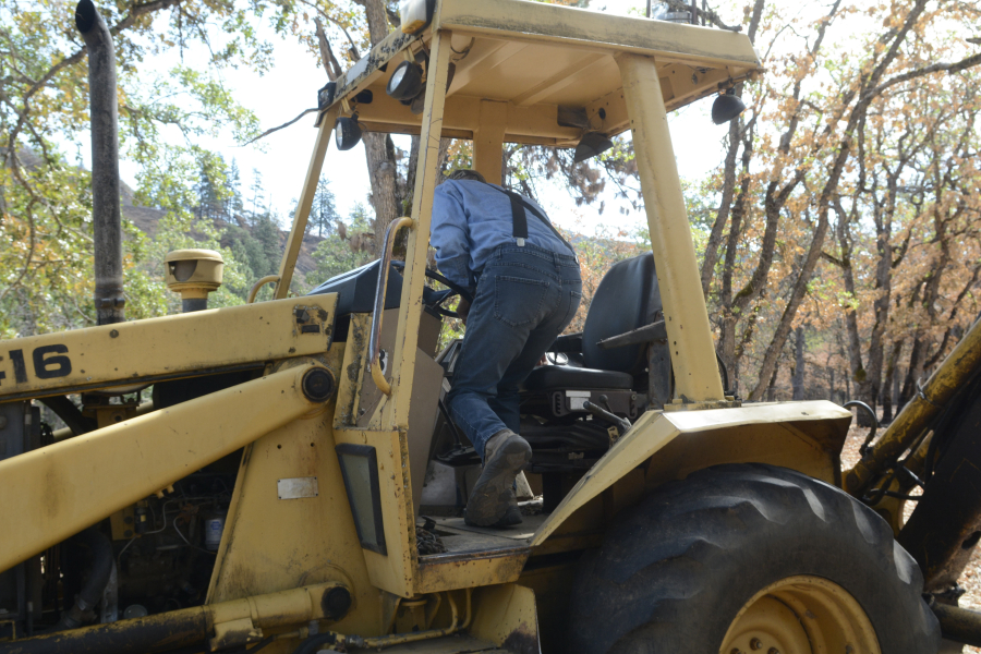 Charlie Deach used his backhoe to dig berms around the Columbia Grange Hall near Lyle to save it from the Burdoin Fire. (Emily Rogers/The Columbian)