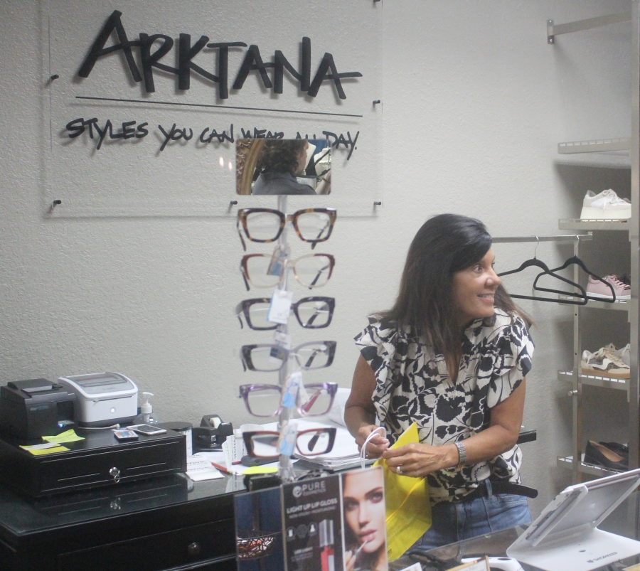 Katie Thomas, manager of the Arktana women&rsquo;s boutique in downtown Camas, talks with a customer while ringing up the customer&rsquo;s purchase Friday. (Doug Flanagan/The Columbian)