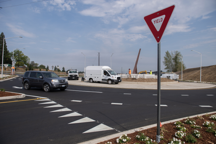 At left, a motorist navigates a new roundabout along Southeast First Street on Wednesday. Construction on the city of Vancouver road improvement project between Southeast 177th and 192nd avenues wrapped up after more than a year. (Amanda Cowan/The Columbian)
