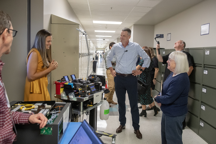 Emily Soukup, from left in yellow, senior process engineer for Camas-based company nLIGHT, talks with CEO Scott Keeney and U.S. Sen. Patty Murray, D-Wash., as they visit her station during a tour of the campus on Monday morning. The company was celebrating 25 years in business. (Amanda Cowan/The Columbian)