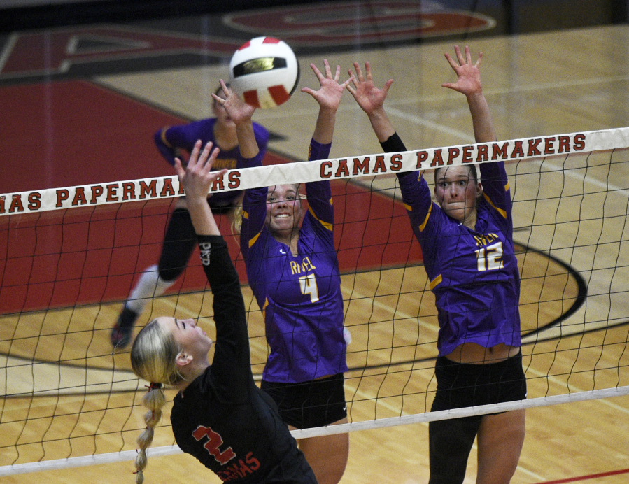 Columbia River juniors Ava Bond (4) and Chiara Cooper (12) attempt to block a kill by Ella Thompson of Camas during Monday&rsquo;s non-league volleyball match at Camas High School. Camas won in four sets. (Micah Rice/The Columbian)